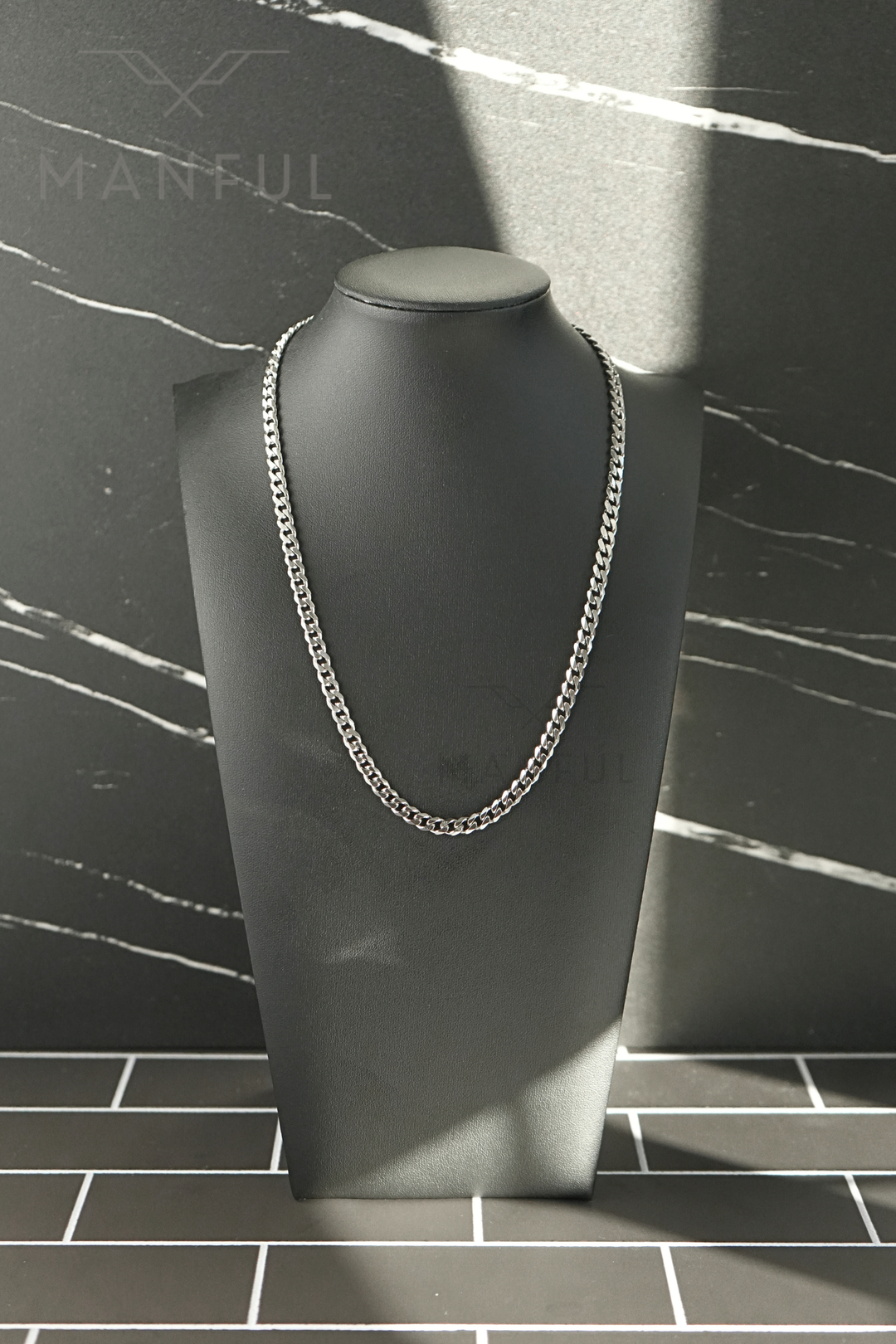 Cuban Chain 5mm Silver, displayed on a dark bust with a marble tile background