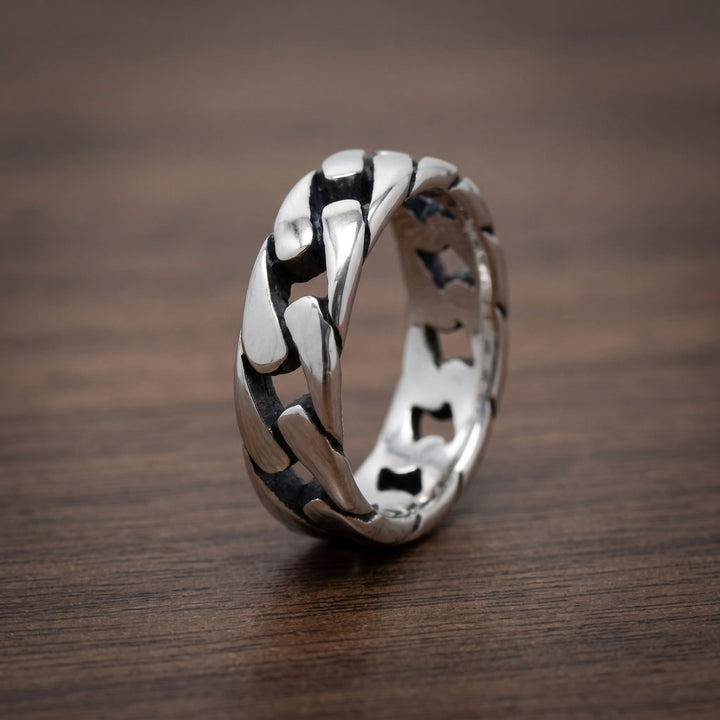 Cuban Chain Ring (Silver) standing upright on a walnut table
