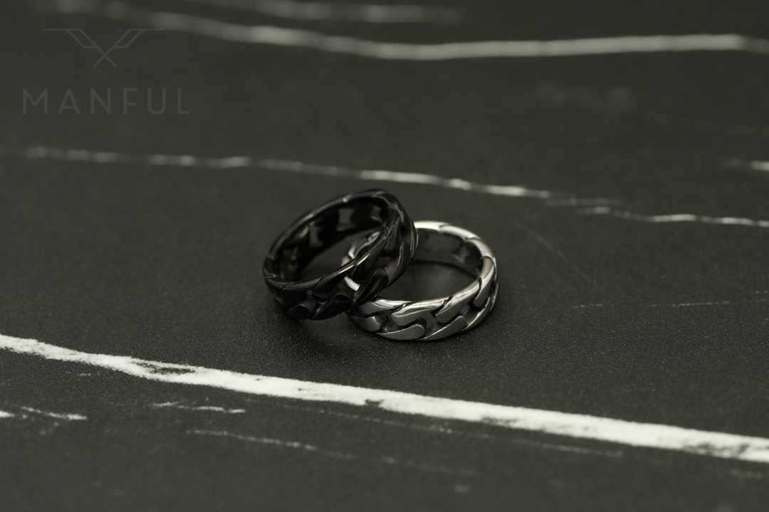 Cuban Chain Ring Silver, leaning against its black colourway on a dark marble surface