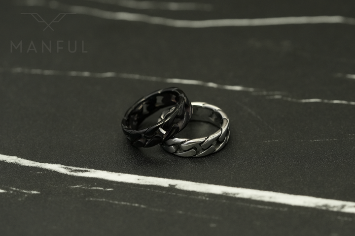 Cuban Chain Ring Silver, leaning against its black colourway on a dark marble surface