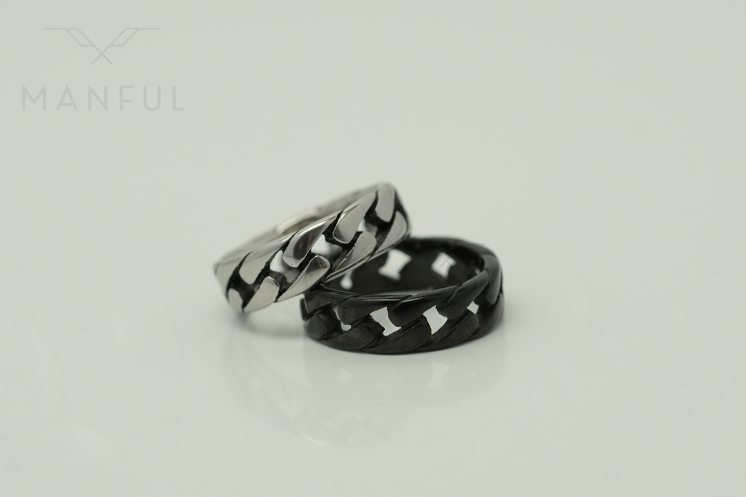 Cuban Chain Ring Silver, propped in front of its black colourway on a light background