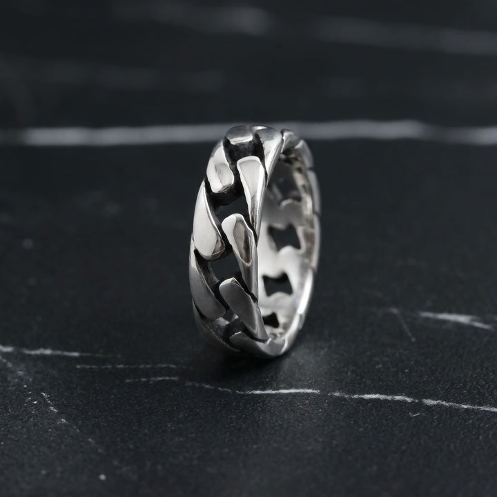 Cuban Chain Ring (Silver) standing upright on black marble with thin white veins