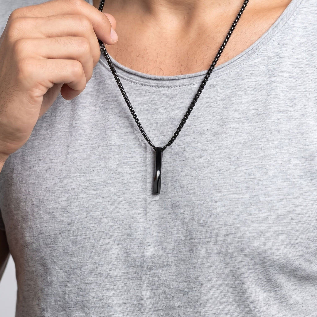 Cuboid Pendant Chain (Black) on a man's chest as he holds the chain near his collar