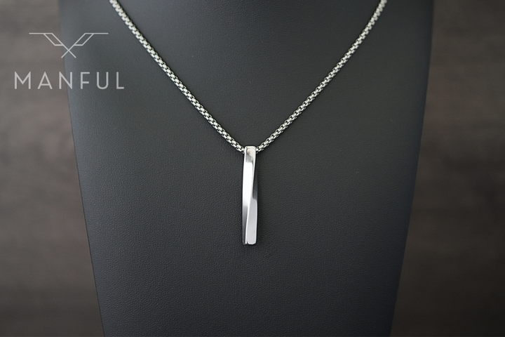 Cuboid Pendant Chain Silver, displayed close on a dark grey neck bust against a marble backdrop