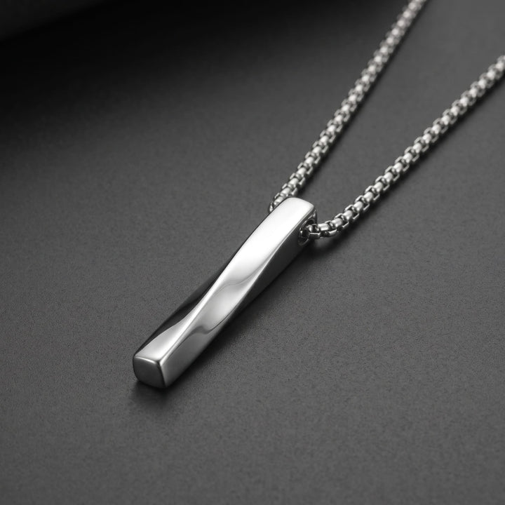 Cuboid Pendant Chain (Silver) lying on a dark charcoal surface