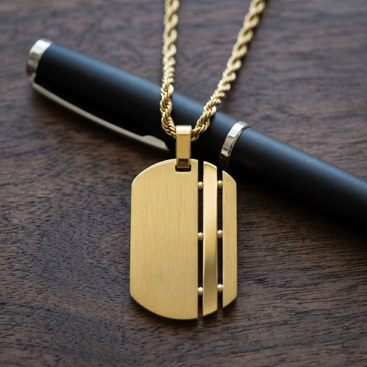 Dog Tag Chain (Gold) over a black pen on a walnut desk