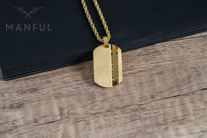 Dog Tag Chain Gold, close-up on the corner of a black book with the chain looped over the spine