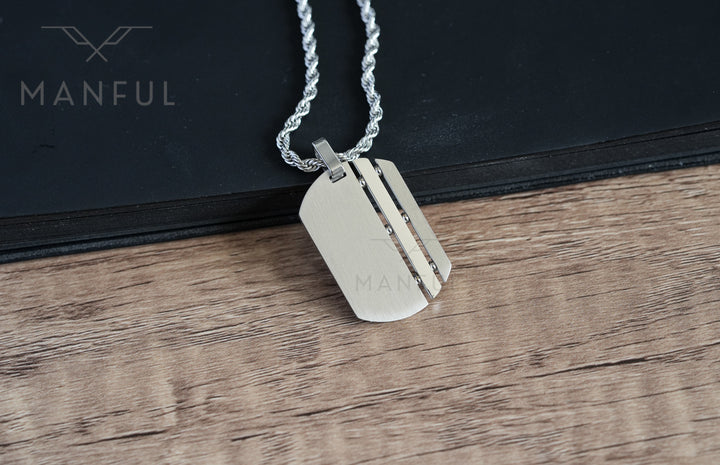 Dog Tag Chain Silver, lying flat on the wood surface in front of a book