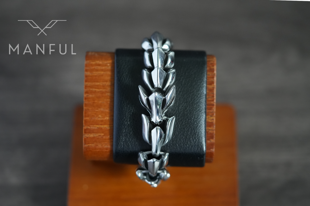 Dragon Link Bracelet Silver, wrapped upright around a wooden stand against black leather