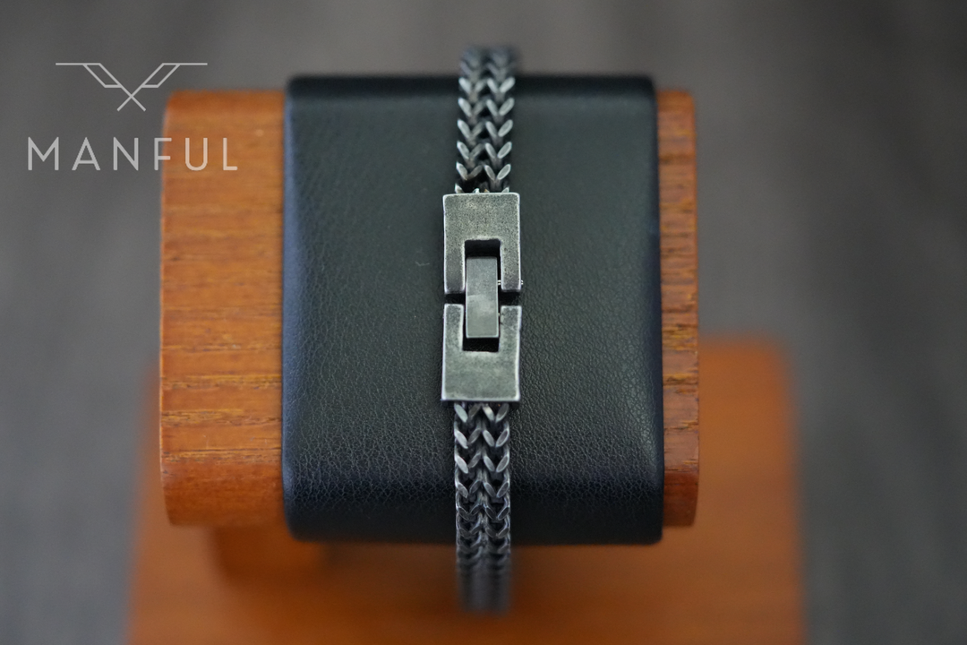Foxtail Bracelet Dark Grey, wrapped around a leather wrist display stand with the clasp closed