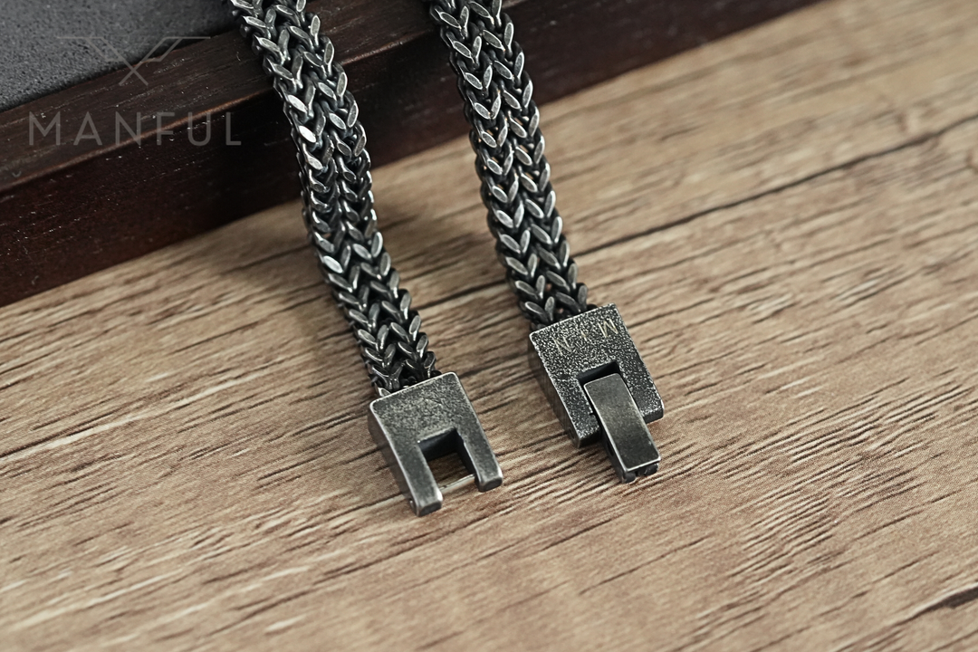 Foxtail Bracelet Dark Grey, close-up of the open box clasp on a wood surface