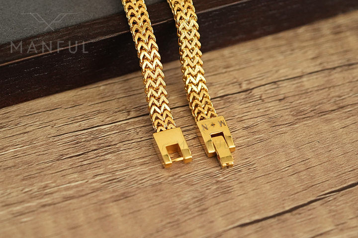 Foxtail Bracelet Gold, close-up of the box clasp with the woven chain resting on a wood surface