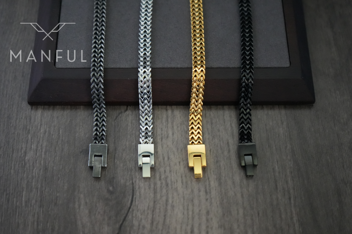 Foxtail Bracelet Gold, laid out beside three other colourways on a wood surface