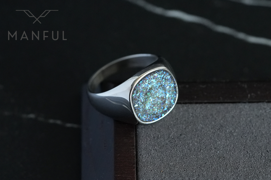 Galaxy Signet Ring, propped on a wooden box corner against a dark marble surface