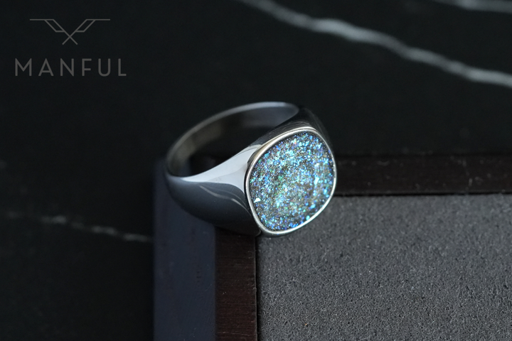 Galaxy Signet Ring, propped on a wooden box corner against a dark marble surface