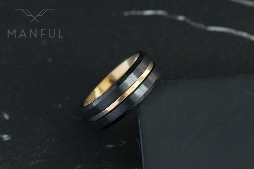 Gold & Black Band, leaning against a dark box edge on marble