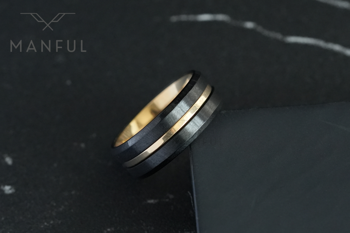 Gold & Black Band, leaning against a dark box edge on marble