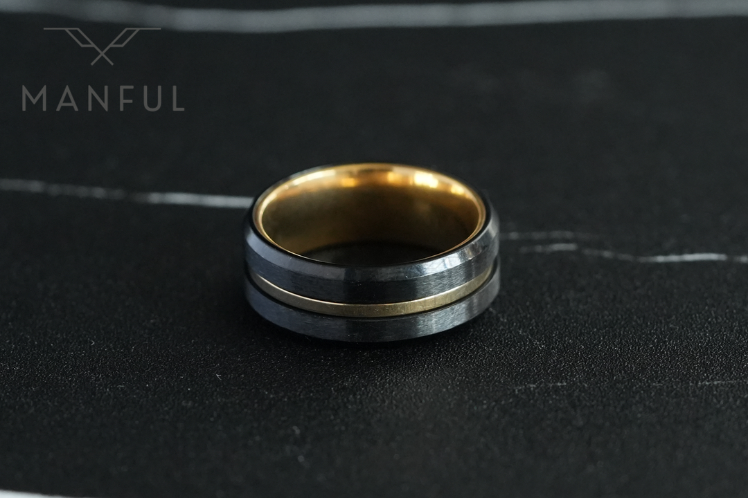 Gold & Black Band, facing the camera on a dark marble surface