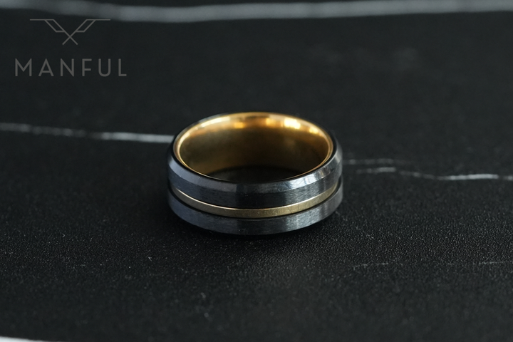 Gold & Black Band, facing the camera on a dark marble surface