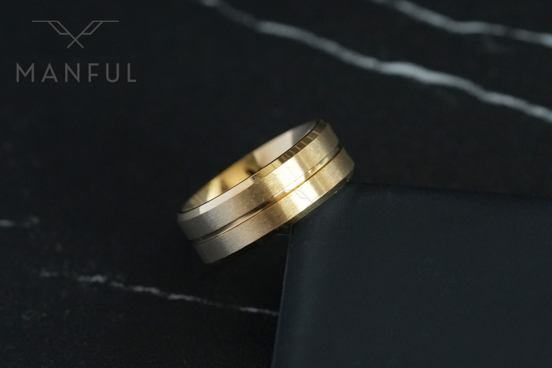 Gold Band, leaning against the edge of a black box on a marble surface