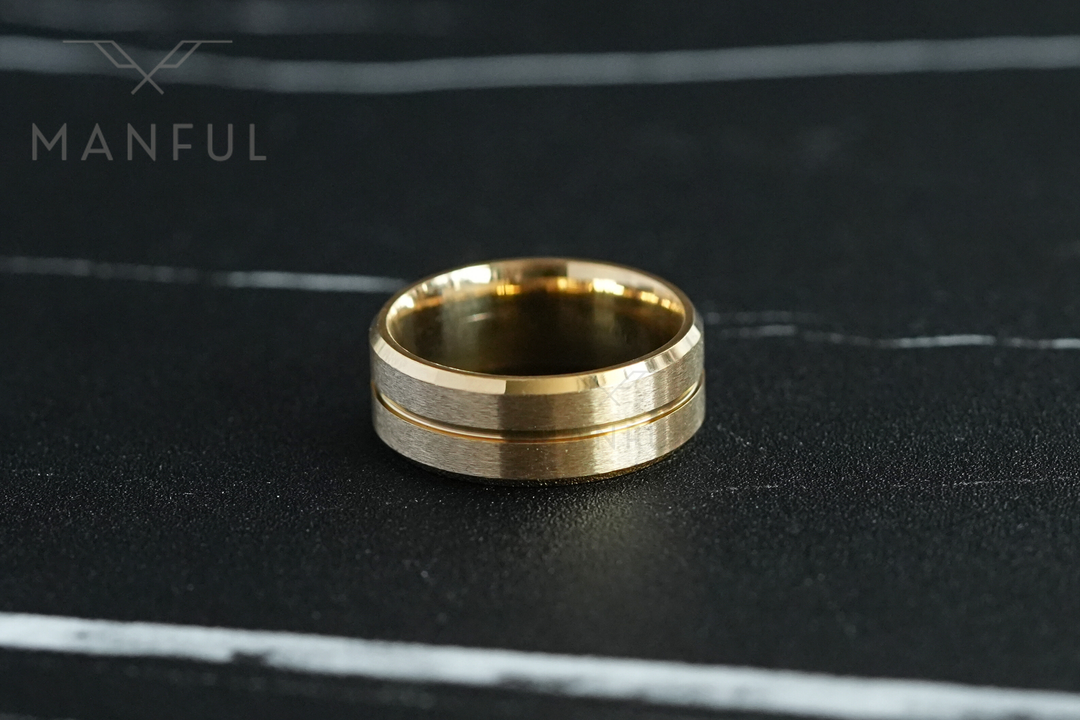 Gold Band, lying flat on a dark marble surface, straight-on view