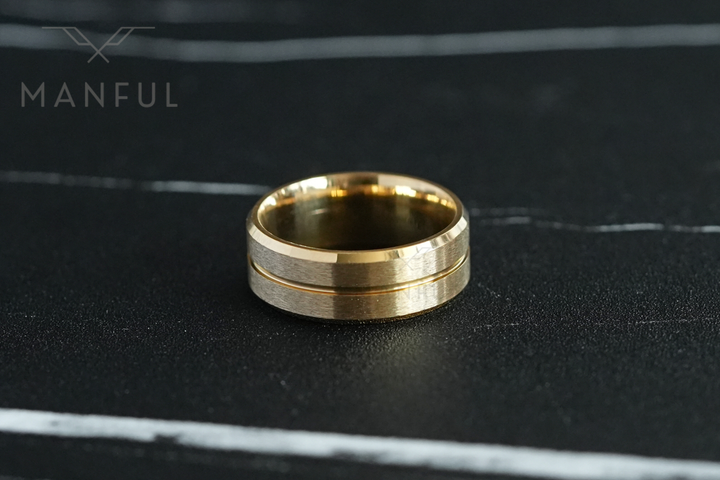 Gold Band, lying flat on a dark marble surface, straight-on view