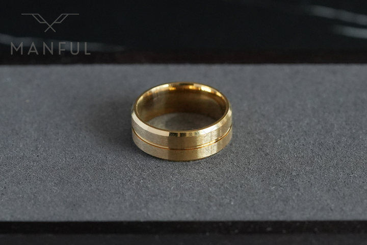 Gold Band, resting on a grey concrete surface near a dark corner