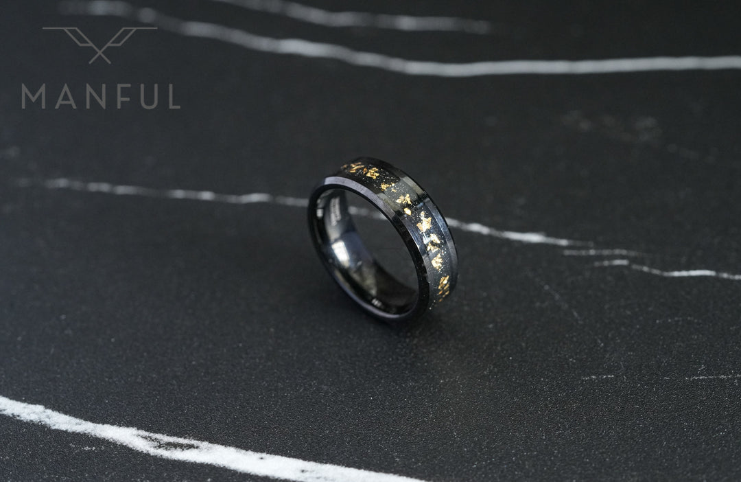 Gold Leaf Inlay Band Black, resting flat on a dark marble surface at an angle