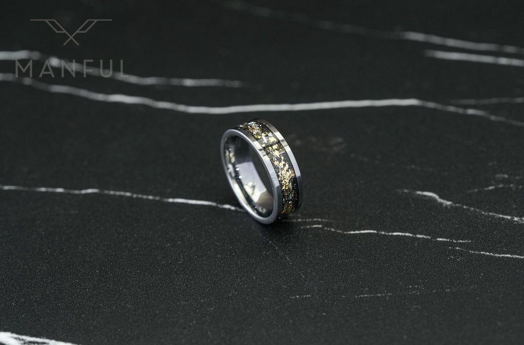 Gold Leaf Inlay Band Silver, tilted on its side on a dark marble surface