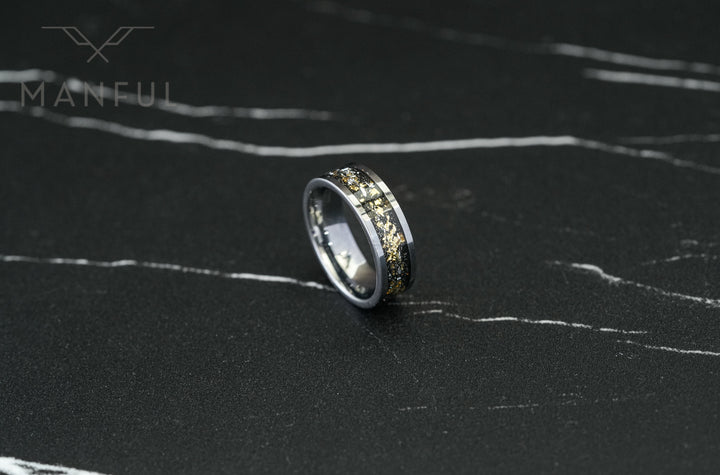 Gold Leaf Inlay Band Silver, tilted on its side on a dark marble surface