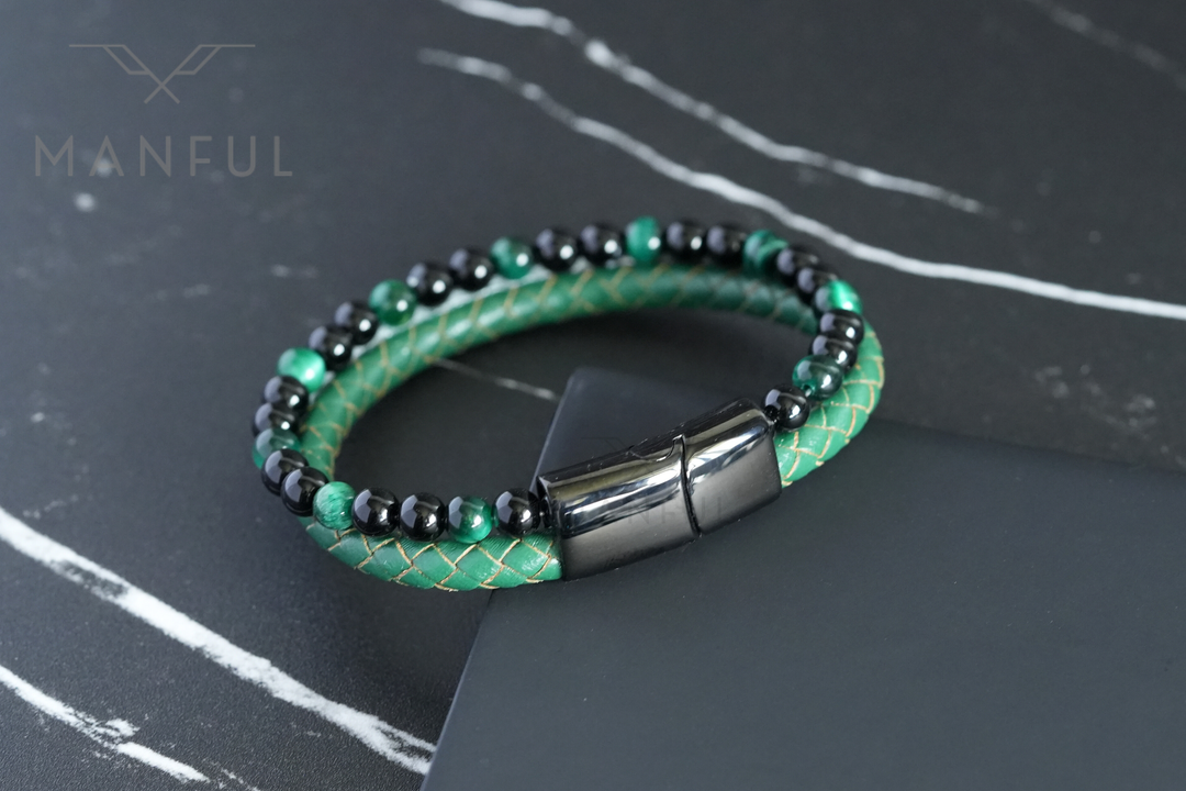 Jade Bead And Leather Bracelet, coiled on a dark marble surface with the gunmetal clasp lower right