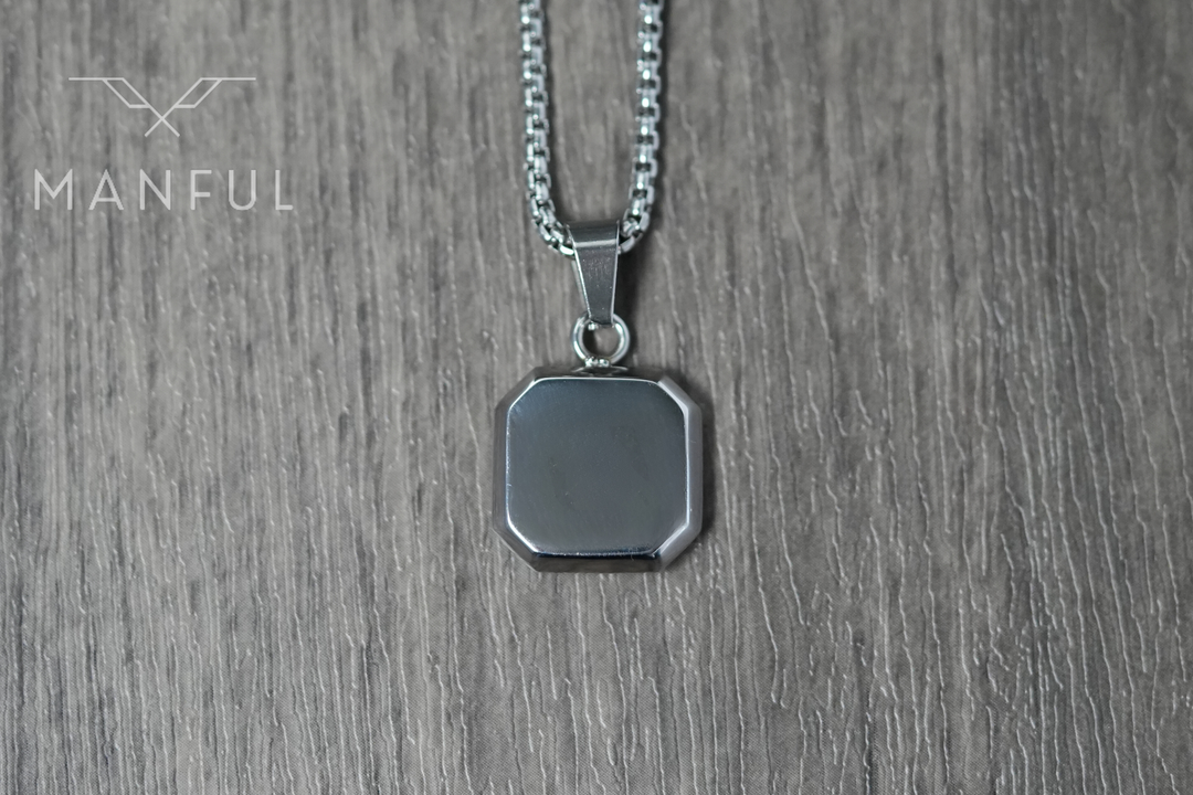 Jade Square Necklace, close-up on a wood surface showing the plain silver back of the pendant