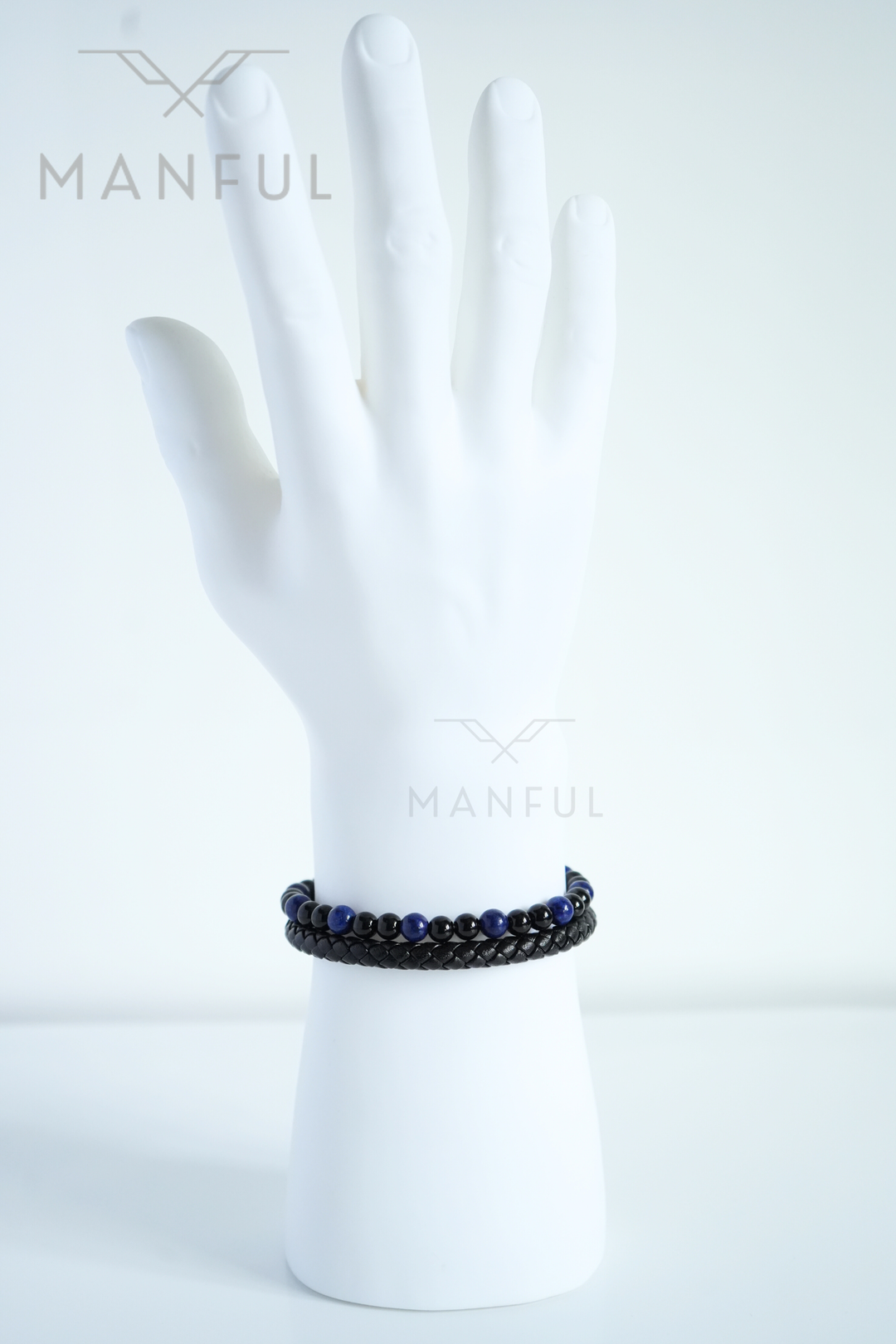 Lapis And Onyx Bead Leather Bracelet, worn on a man's wrist with fingers spread against a white background