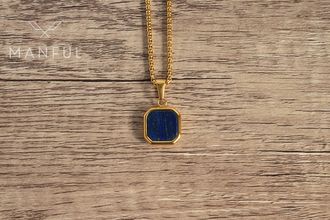 Lapis Square Necklace Gold, hanging against a wood surface facing the camera