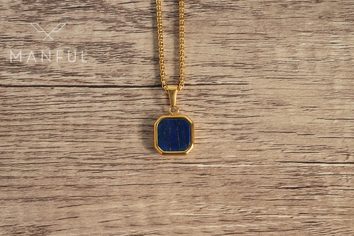 Lapis Square Necklace Gold, hanging against a wood surface facing the camera
