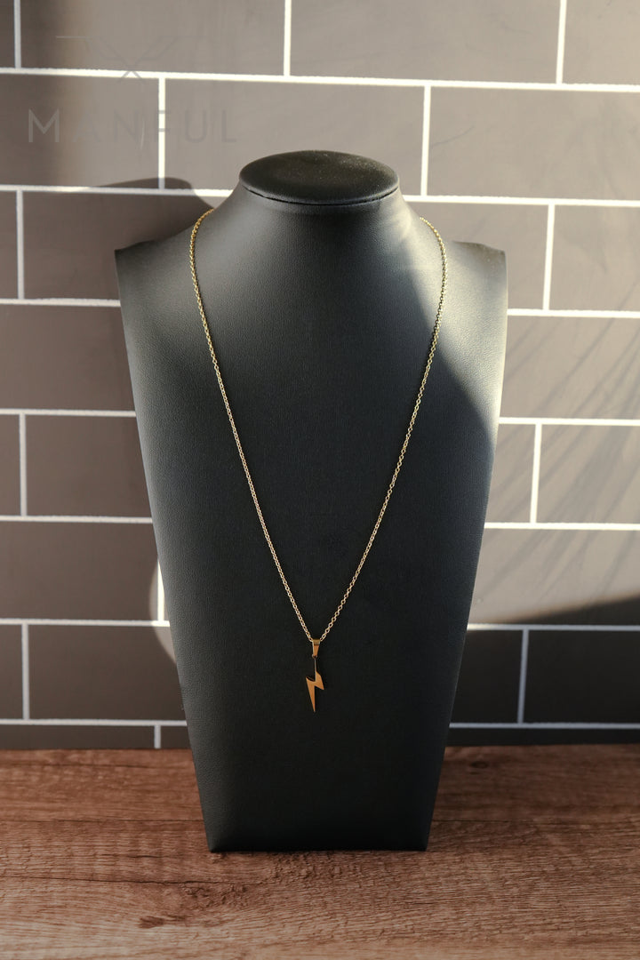 Lightning Pendant Necklace Gold, displayed on a black bust stand against a tiled backdrop
