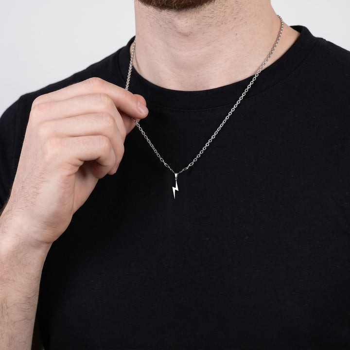 Lightning Pendant Necklace (Silver) on a man's chest as he holds the chain near his collar