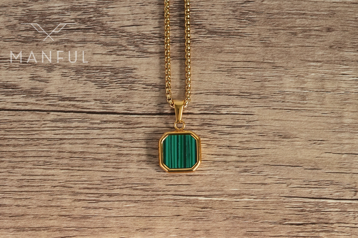 Malachite Square Necklace Gold, flat on a wood surface showing the front of the pendant