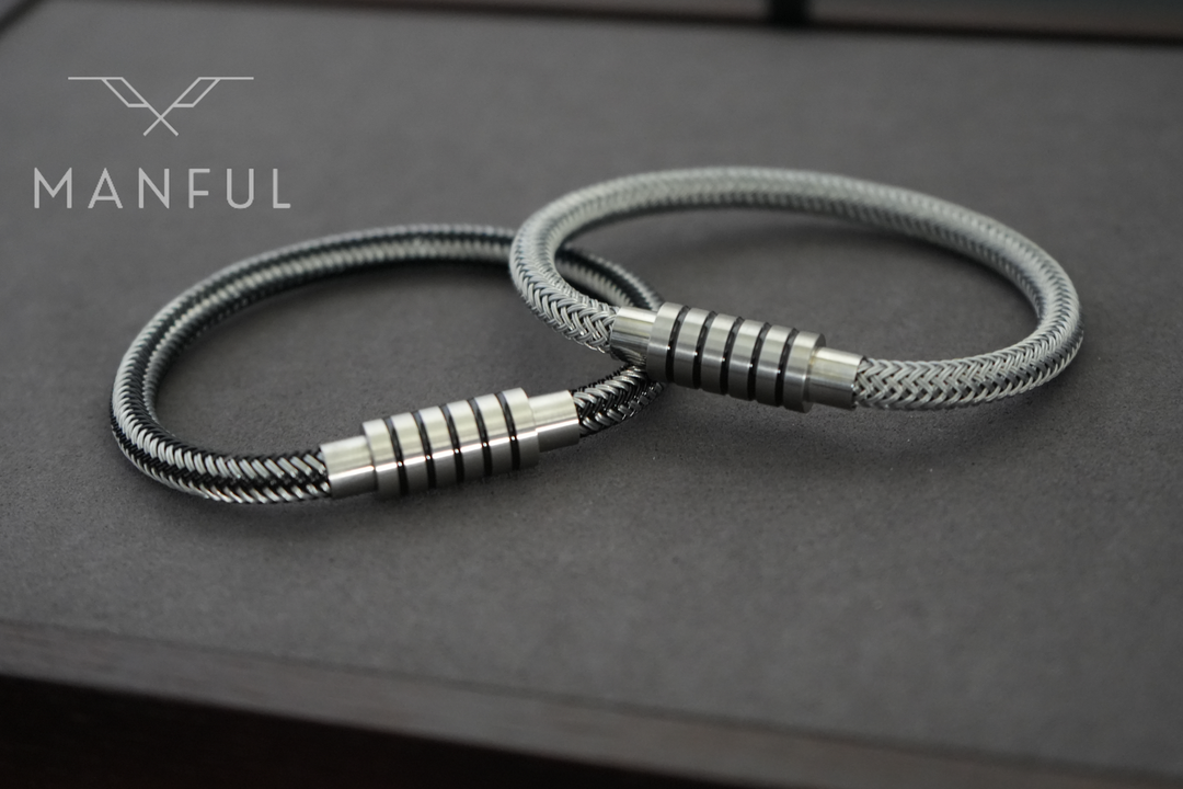 Steel Wire Bracelet Silver, paired with the black variant side by side on a grey surface
