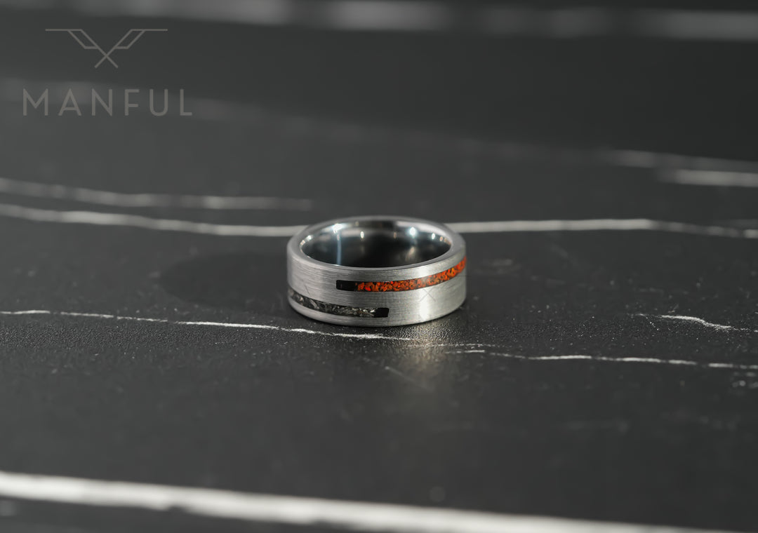 Meteorite & Dinosaur Bone Inlay Band, lying flat on a dark marble surface with the inlay facing forward