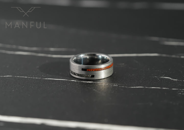 Meteorite & Dinosaur Bone Inlay Band, lying flat on a dark marble surface with the inlay facing forward