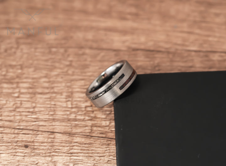 Meteorite & Dinosaur Bone Inlay Band, leaning against a black block on a wood surface