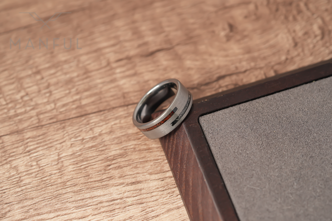 Meteorite & Dinosaur Bone Inlay Band, resting on a wood surface against a dark wooden corner from above