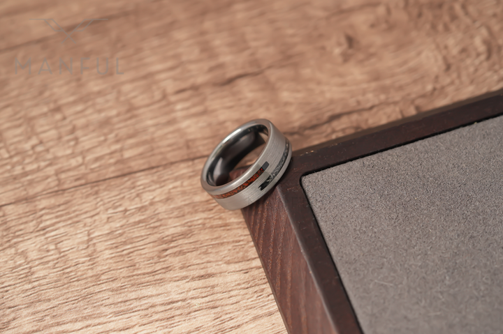 Meteorite & Dinosaur Bone Inlay Band, resting on a wood surface against a dark wooden corner from above