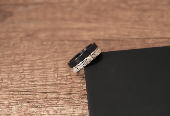 Midnight Antler Band, resting on a wood surface beside a black card corner