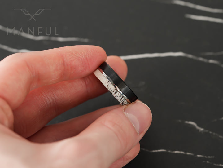 Midnight Antler Band, held between finger and thumb against a dark marble backdrop