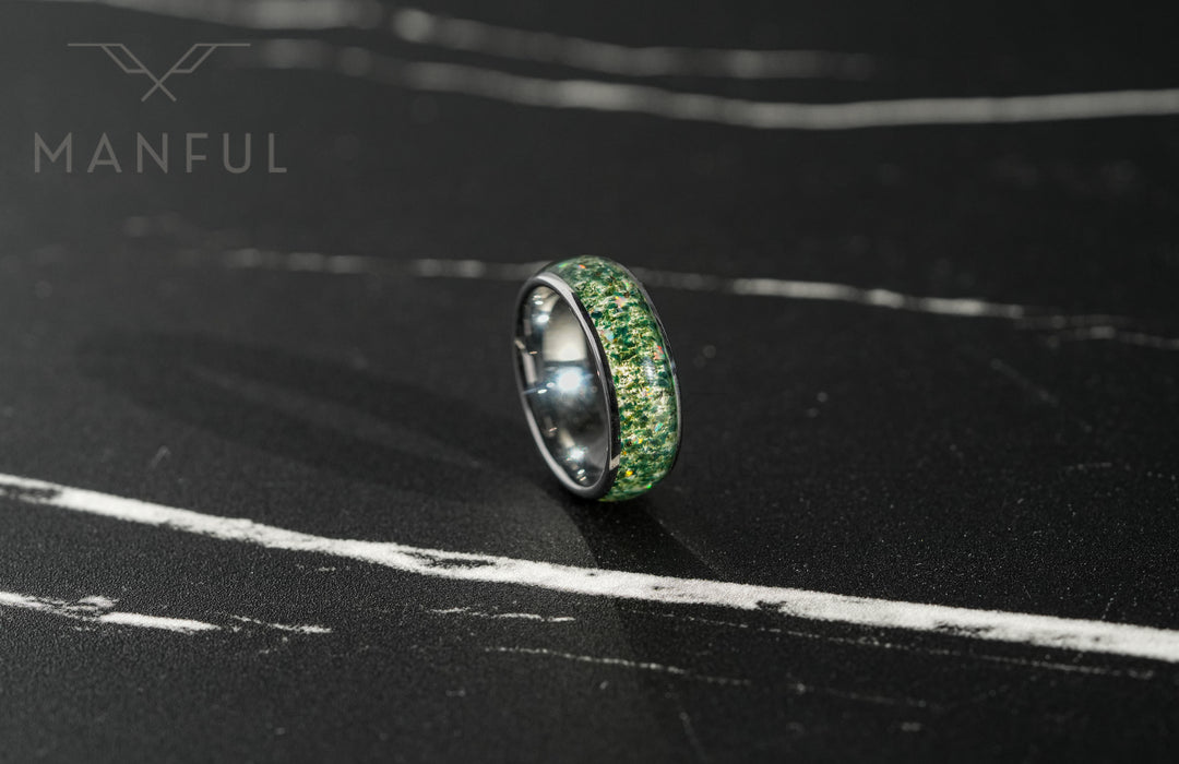 Moss Agate & Crushed Opal Ring, tilted on a dark textured surface with the green inlay facing forward
