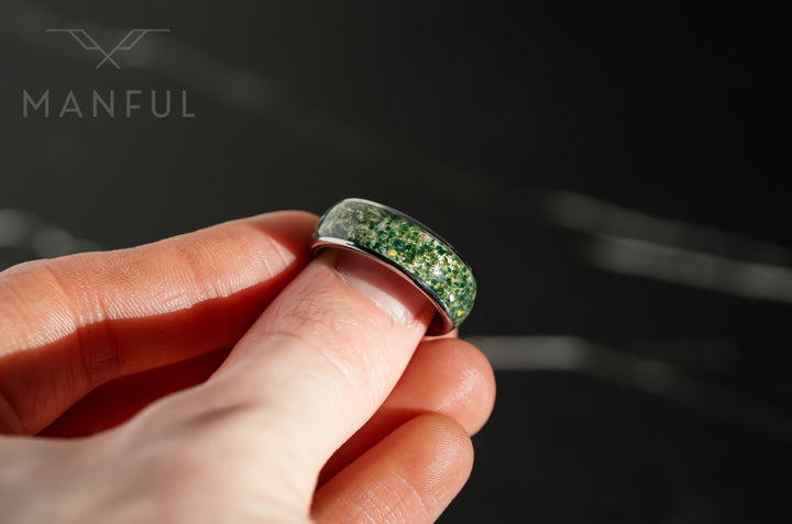 Moss Agate & Crushed Opal Ring, held between finger and thumb in a close-up of the green stone inlay