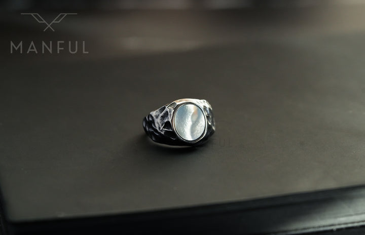 Mother of Pearl Signet Ring, standing upright on a plain dark background close-up