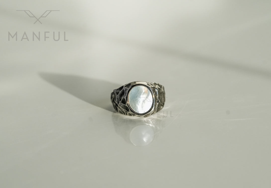 Mother of Pearl Signet Ring, standing upright on a plain white surface with a soft reflection